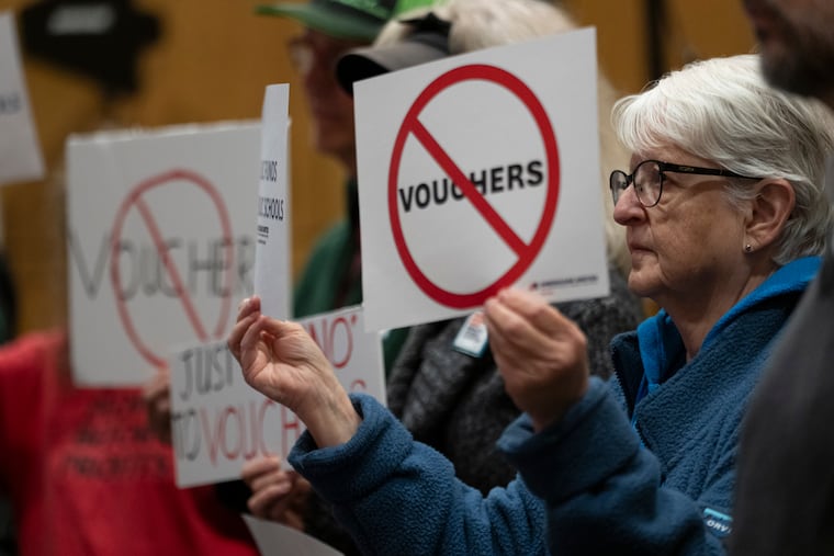 Mirabelle Stoedter holds a sign against school vouchers during a news conference on Tuesday, Nov. 28, 2023, in Nashville. Tennessee Gov. Bill Lee presented the Education Freedom Scholarship Act of 2024, his administration's legislative proposal to establish statewide universal school choice.