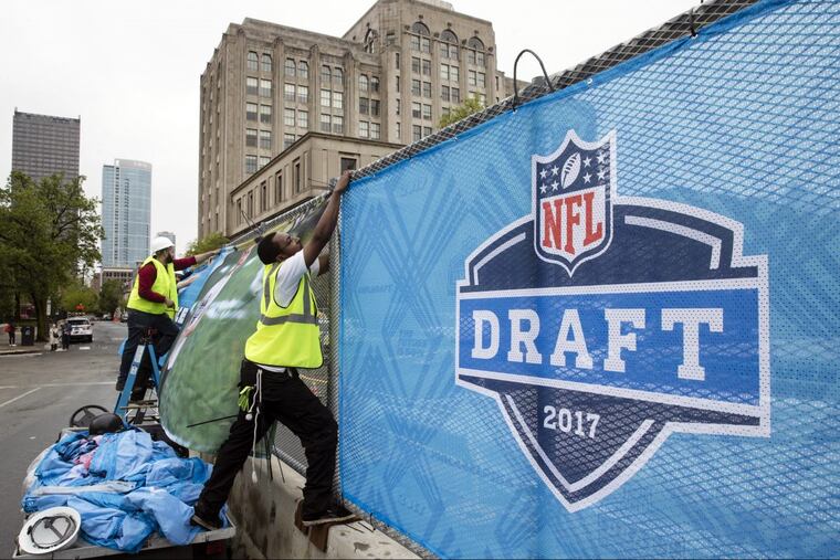 Workers make preparations ahead of the 2017 NFL draft on the Parkway.