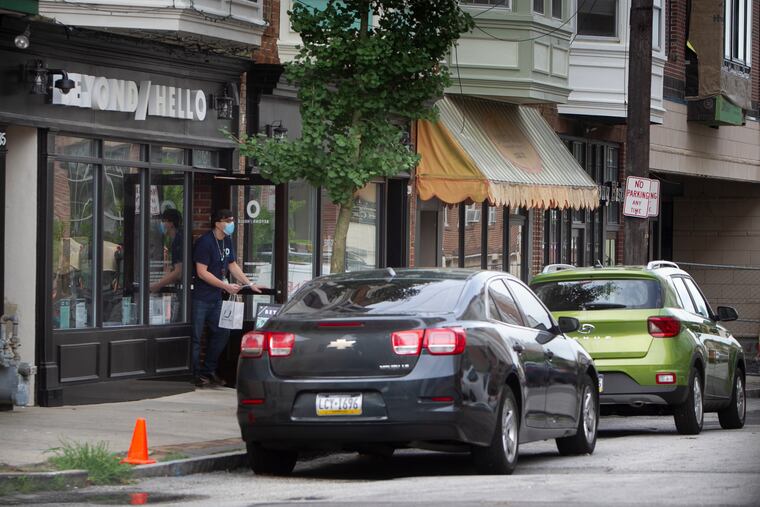 Curb service for patron of Beyond / Hello a cannabis dispensary at 35 Cricket Avenue in Ardmore, PA on Thursday, August 13, 2020. Employee delivers to little green car.