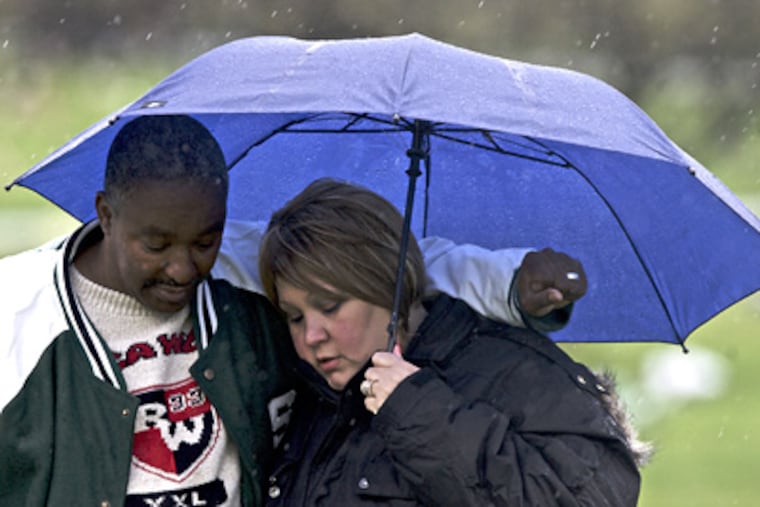 Shelly Scott and Larry Adkins visit the grave of their son LaVonne Adkins in Cinnaminson, N.J. (John Costello / Staff Photographer)