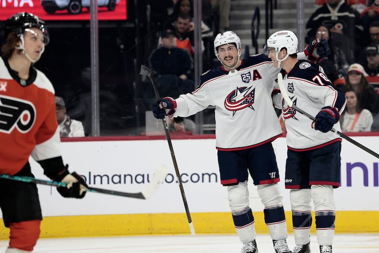 Blue Jackets Zach Werenski (center) and Damon Severson celebrate one of two second period goals against the Flyers.