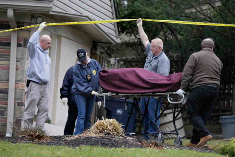 A gurney with the body of Richard Porter, 68, who was killed in his home in Wayne, is rolled away by police and Montgomery County officials. Porter was a painting contractor.