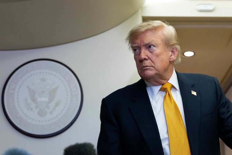 President Donald Trump speaks with reporters on Air Force One after landing at U.S. Air Force Base at RAF Mildenhall, in Suffolk, England on Wednesday.