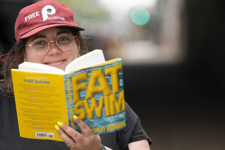 Emma Copley Eisenberg with her book “Fat Swim” near a billboard along Interstate 95 promoting the new release, Monday, April 13, 2026.