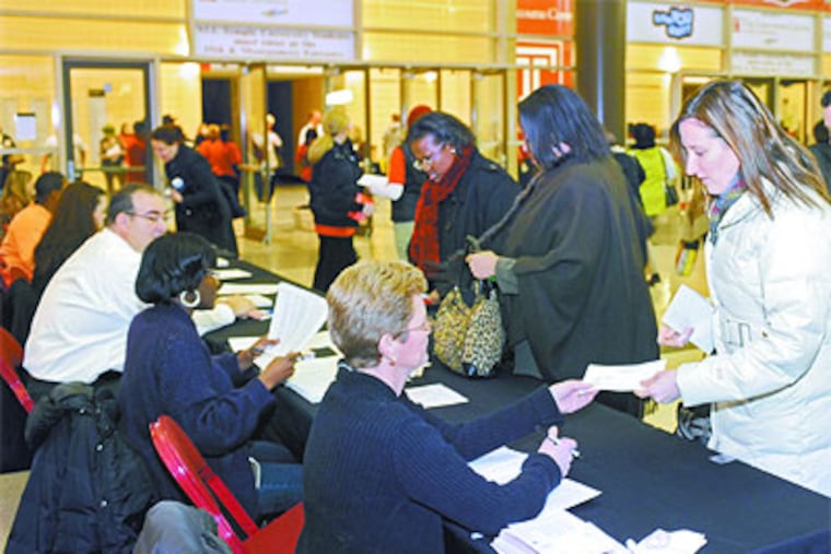 Christine Demore (right), a third grade teacher at J.H. Moore Elementary School, checks in Thursday to get her pass into the Liacouras Center where the Philadelphia Federation of Teachers learned of their new labor agreement with the School District. (Clem Murray / Staff Photographer)