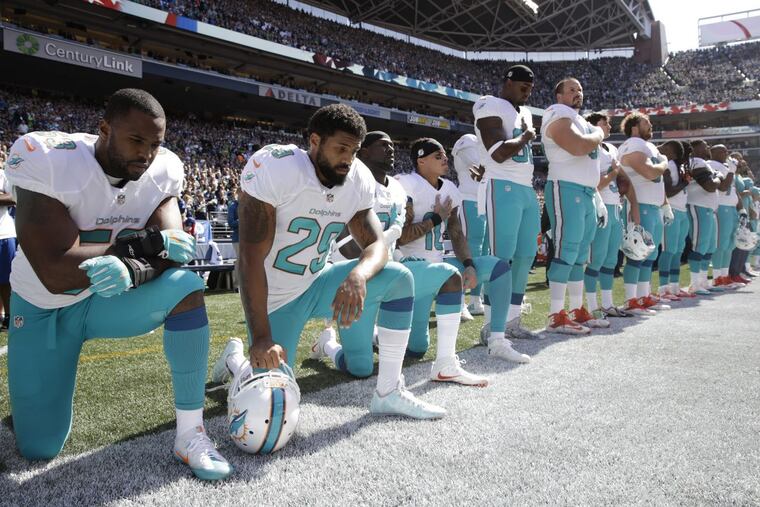 Miami Dolphins players kneel during the singing of the national anthem before a game against the Seattle Seahawks in September.