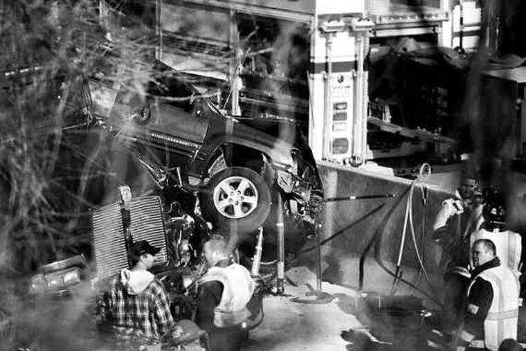 Police and rescue officials investigate the deadly crash on I-76. A truck driver, apparently unable to stop in time, slammed into a line of traffic.