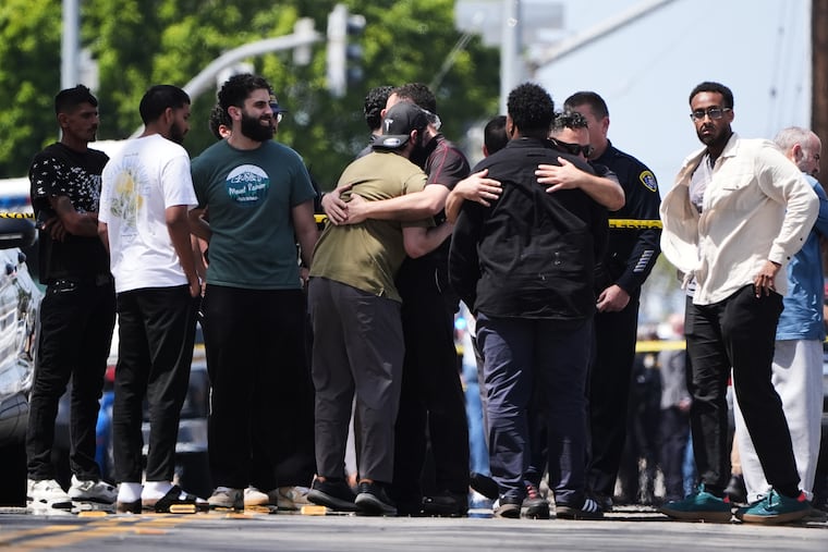 People embrace near the scene of a shooting outside the Islamic Center of San Diego Monday, May 18, 2026, in San Diego.