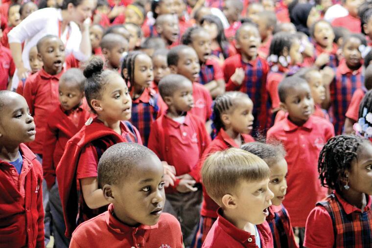 File: Elementary school students participate in an indoor rally in May to help prevent their school, Walter D. Palmer Leadership Learning Partners Charter School, from closing. (VIVIANA PERNOT/Staff Photographer)