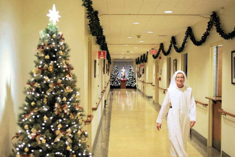 Sister Mary Barbara Randolph passes through the hallway at Sacred Heart Free Home for Incurable Cancer, Dec. 23, 2014. Since 1930, the Dominican Sisters of Hawthorne have cared for people at the end of their lives in a once-grand home in Hunting Park. (TOM GRALISH/Staff Photographer)