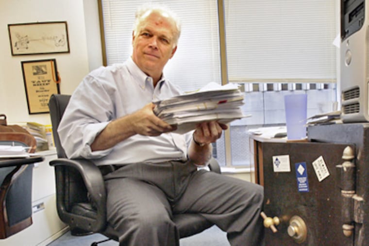Senior controller Biff Hastings displays a stack of about $1 million in payments to Caring People Alliance vendors that have been frozen because there is no money to cover them. (Elizabeth Robertson / Staff Photographer)
