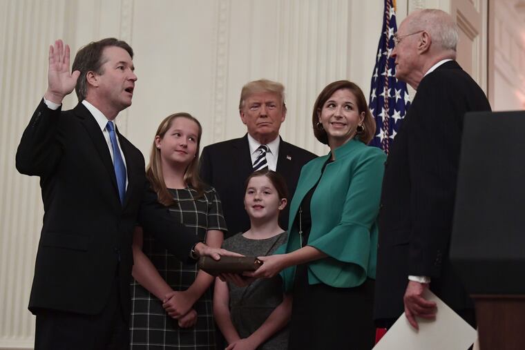 President Donald Trump, center, listens as retired Supreme Court Justice Anthony Kennedy, right, ceremonially swears-in Supreme Court Justice Brett Kavanaugh, left, in the East Room of the White House in Washington, Monday, Oct. 8, 2018.