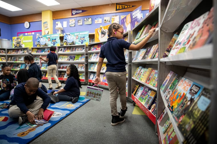 First grader Brielle Nichol, 7, browses the books at a book fair at a Philadelphia elementary school in March 2022.