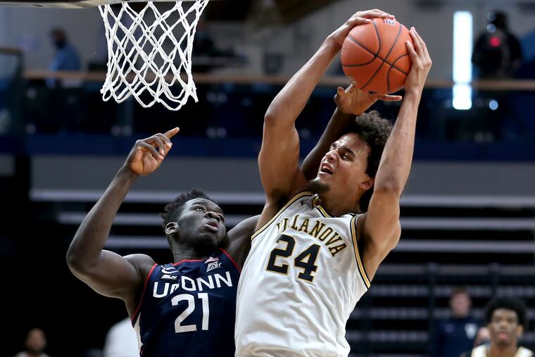 Jeremiah Robinson-Earl pulls down a rebound against Adama Sanogo of UConn.