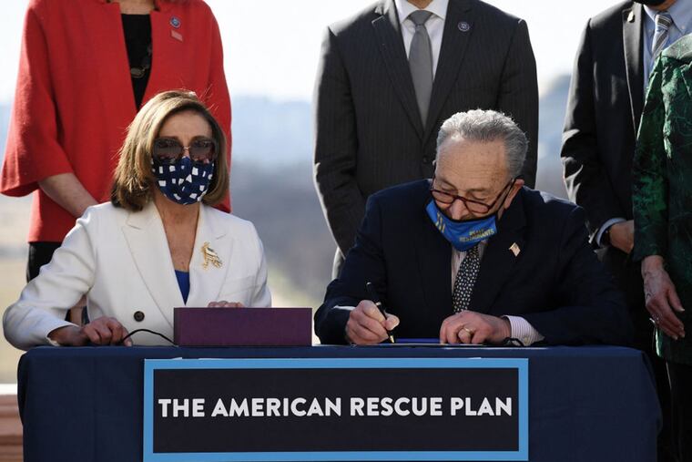 Speaker of the House Nancy Pelosi (left) and Senate Majority Leader Chuck Schumer sign the American Rescue Plan Act after the House Chamber voted on the final revised legislation of the $1.9 trillion COVID-19 relief plan, at the US Capitol on March 10, 2021 in Washington, DC.