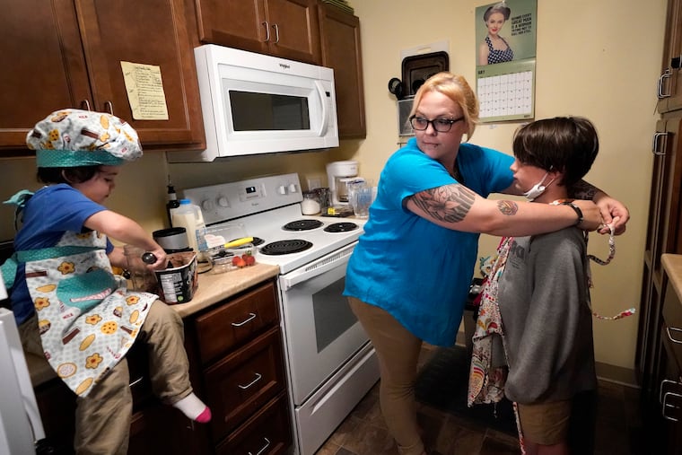 In this July 28, 2021, photo, Christina Darling and her sons, Brennan, 4, (left) and Kayden, 10, prepare a snack at home in Nashua, N.H. Darling and her family qualified for the expanded child tax credit, part of President Joe Biden's $1.9 trillion coronavirus relief package. "Every step closer we get to a livable wage is beneficial. That is money that gets turned around and spent on the betterment of my kids and myself," said Darling, a housing resource coordinator who had been supplementing her $35,000-a-year salary with monthly visits to the Nashua Soup Kitchen and Shelter's food pantry.