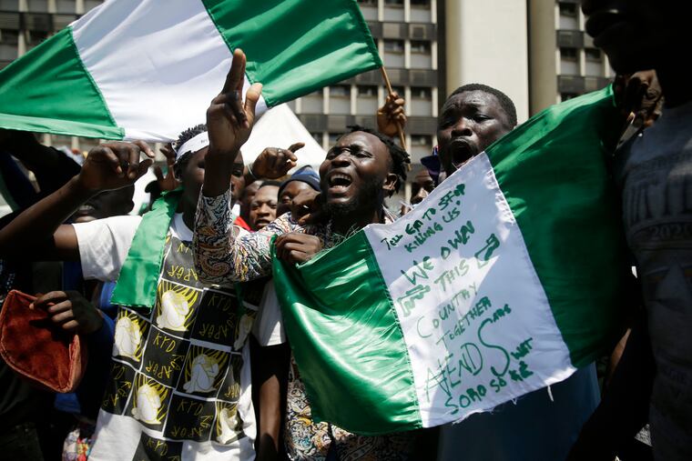 People hold banners as they demonstrate on the street to protest against police brutality in Lagos, Nigeria, on Tuesday.
