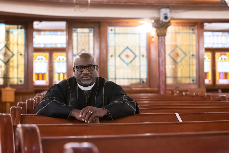 The Rev. Mark Kelly Tyler poses for a portrait in the pews after delivering Sunday Service on the morning of Nov. 27, 2022 at Mother Bethel AME Church in South Philadelphia. Rev. Tyler is the 52nd pastor of the church which has served as a spiritual, social, and community center since its founding in 1794.