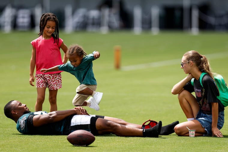 Eagles running back Saquon Barkley plays with his daughter Jada and son Saquon Jr. as his fiancée, Anna Congdon, looks on during training camp in July.