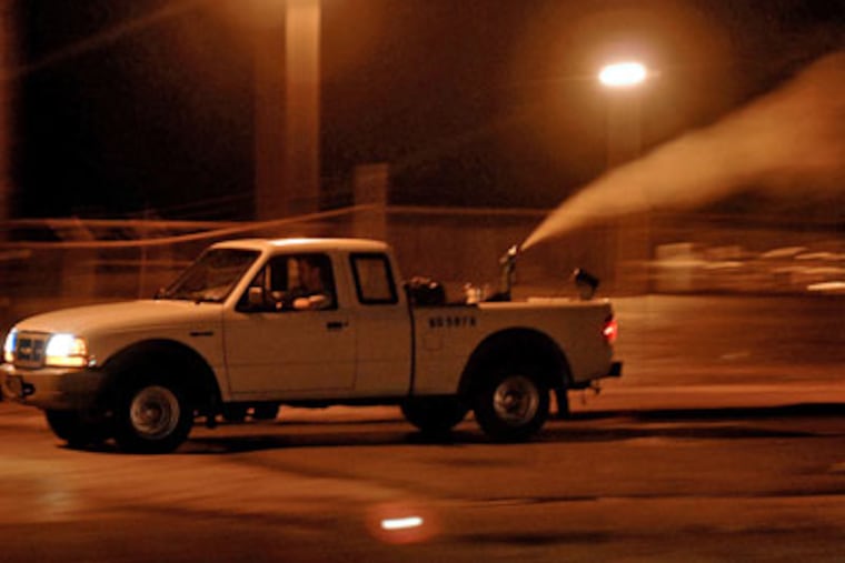 The DEP sprays pesticide to control mosquitoes in Norristown on Tuesday. (Tom Gralish/Inquirer)