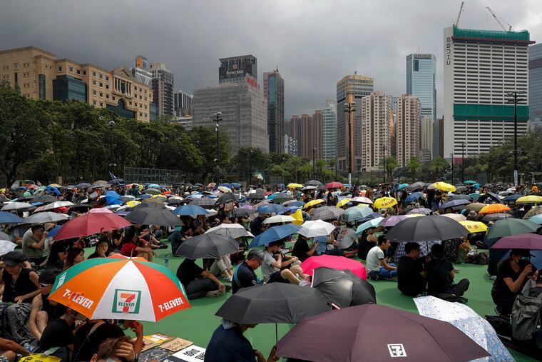 People holding umbrellas gather at Victoria Park to take part in an anti-extradition bill protest in Hong Kong, Sunday, Aug. 11, 2019. Protesters have begun gathering at the park in central Hong Kong for another day of demonstrations that have generally started peacefully but often ended in violent clashes with police. (AP Photo/Vincent Thian)