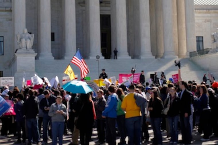 Supporters and opponents of health care reform rally in front of the Supreme Court in Washington, as the court continues arguments on the health care law signed by President Barack Obama. (AP Photo/Charles Dharapak)