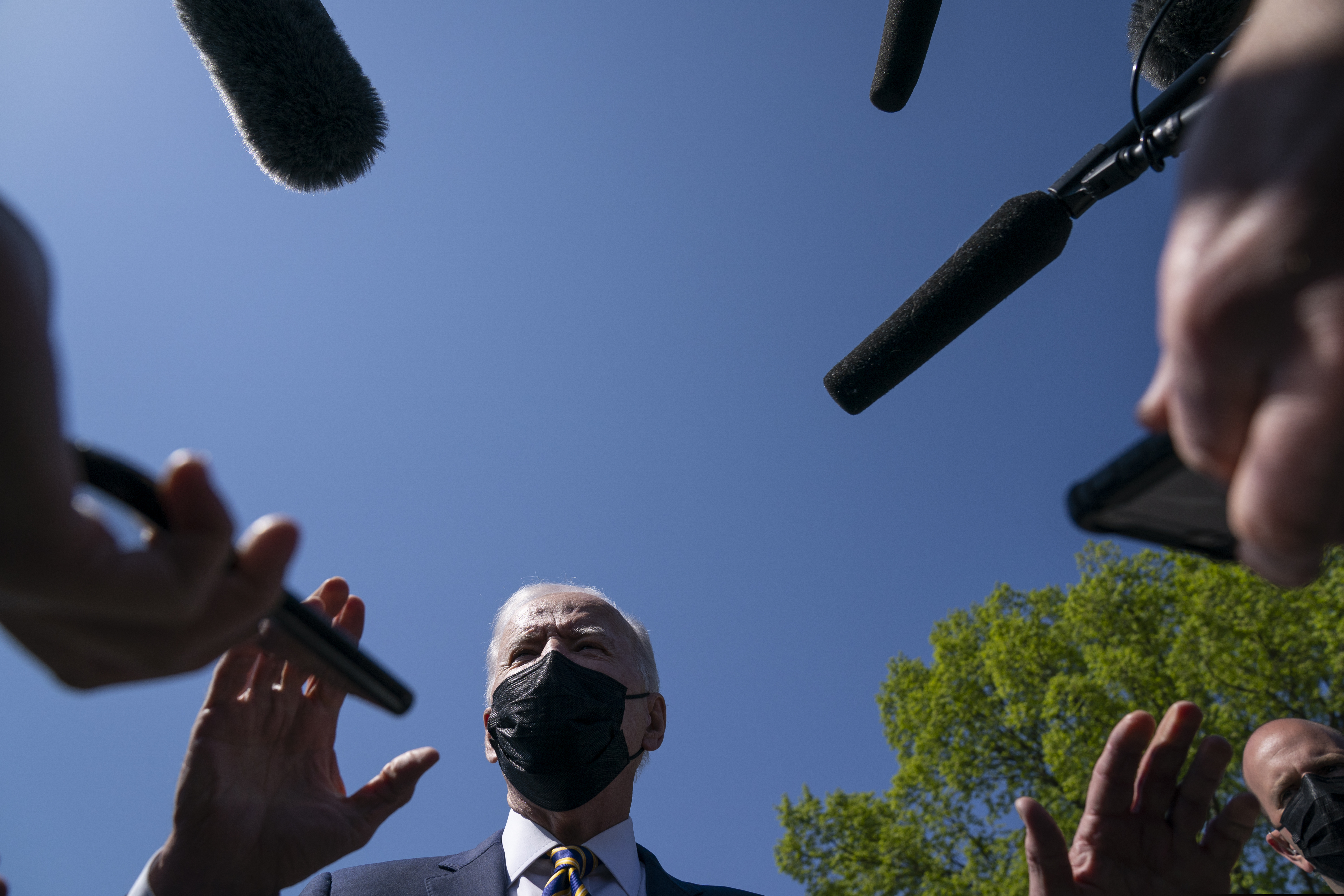 President Joe Biden talks with reporters Monday on the Ellipse on the National Mall after spending the weekend at Camp David.