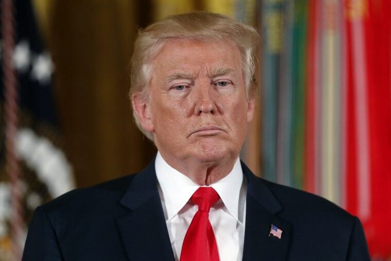 President Donald Trump stands as he waits to bestow the Medal of Honor to retired Army medic James McCloughan on Monday