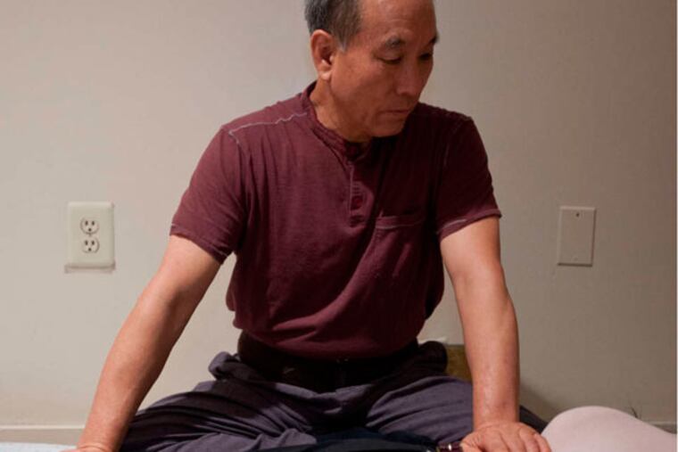 Chi healing master Seok Seo Park of South Korea works with a client at the Health Connections Center. He will return to Philadelphia for 10 weeks beginning in early October.