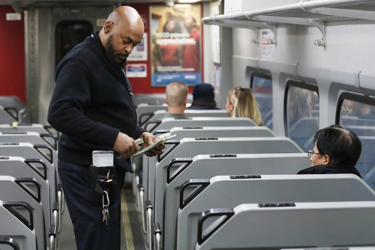 Conductor Wayne Smith checks tickets on the Media/Elwyn R3 line into the city Friday October 27, 2017.