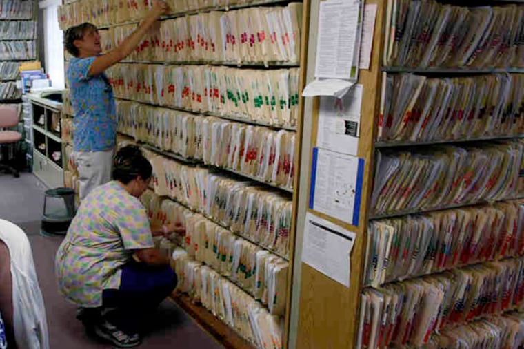 Paper patient files at William Funk's three-doctor practice in Newark, Del., in 2011. The goal of sharing electronic medical records among hospitals, doctors, pharmacies, and labs is to improve care. (File photo)