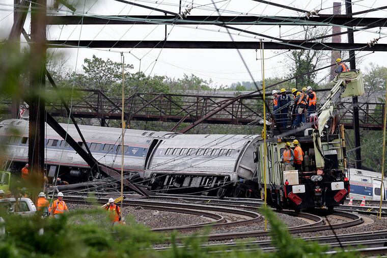 Emergency personnel on Wednesday, May 13, 2015, work at the scene of a deadly train derailment in Philadelphia. ( AP Photo / Mel Evans )