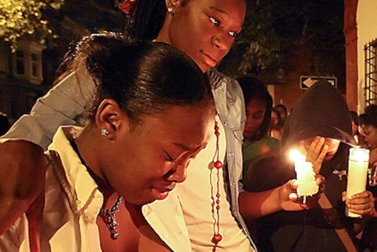 Friends and family gather for a vigil to remember Akhir "Geedy" Frazier. (Steven M. Falk/Staff Photographer)