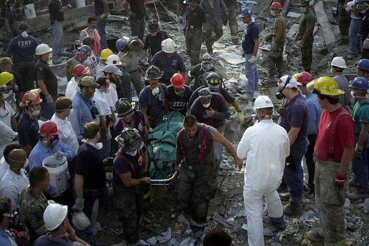 TERROR David Swanson PREG 09-13-2001 New York City WORLD TRADE CENTER BOMBING IN THIS PHOTO: Rescue workers, some of over a thousand pull a body from the massive amount of debris that was the World Trade Center. 16/many