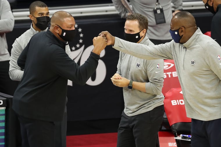 Coach Doc Rivers (left) of the SIxers greets Scott Brooks, center, and members of the Wizards coaching staff before their game at the Wells Fargo Center on Dec. 23.