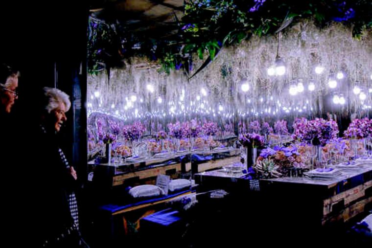 Bob and Maureen McCook of West Chester peek inside one of the cargo-container displays, multi-flowered with complementary lighting.
