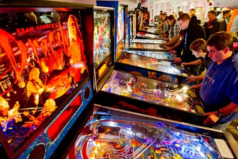 Paul Sarpen, 36, of Downingtown, takes his turn on a pinball machine at one of Pinball Gallery's monthly tournaments. Of the 35 people who competed, nine were younger than 30. (Clem Murray/Staff Photographer)