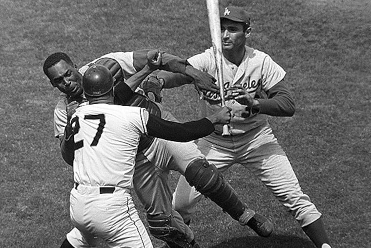 FILE - In this Aug. 22, 1965, file photo, San Francisco Giants pitcher Juan Marichal (27) swings a bat at Los Angeles Dodgers catcher John Roseboro as Dodgers pitcher Sandy Koufax, rear right, tries to break it up in the third inning at Candlestick Park in San Francisco. Violence is part of the game in many sports. But when athletes cross the line it can attract the attention of authorities _ sometimes from within their sport and in other cases from criminal prosecutors. The punishment of four members of the New Orleans Saints for participating a cash-for-hits bounty system targeting opponents is the latest example but not the only one. (AP Photo/Robert H. Houston, File)