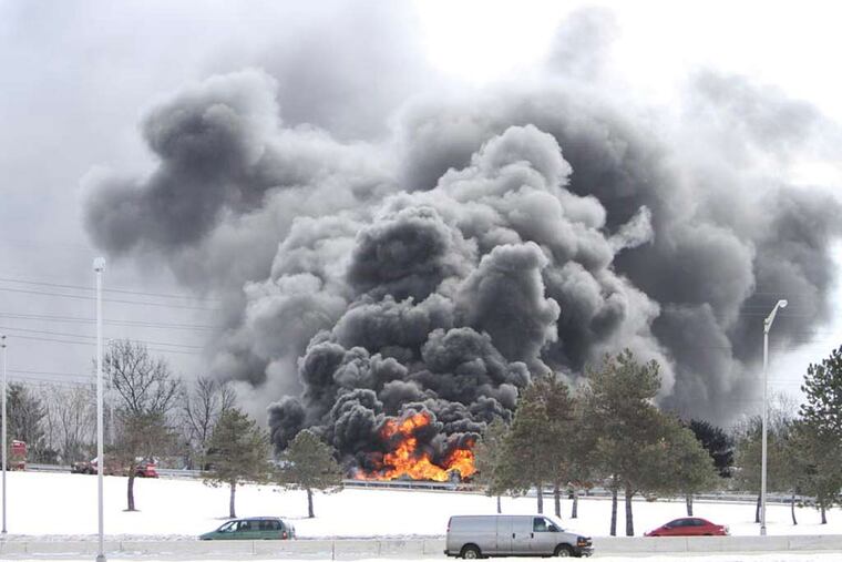 A tanker truck burns out of control, Monday Feb. 23, 2015, after it overturned on an off ramp in Pennsauken NJ. (For the Inquirer and Daily News/ Joseph Kaczmarek)