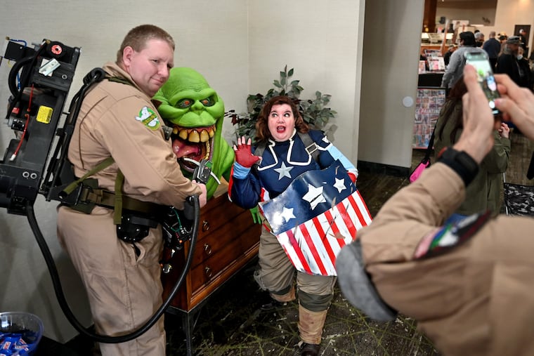 Kristine Knowlton of Millville, dressed as Captain Carter of the Marvel Cinema Universe, poses with the ectoplasm Slimer from Ghostbusters and Chris Gay (left) of Cape May. Fellow Ghostbuster Jeff “Batty” Batt (right), of Wilmington takes the picture.