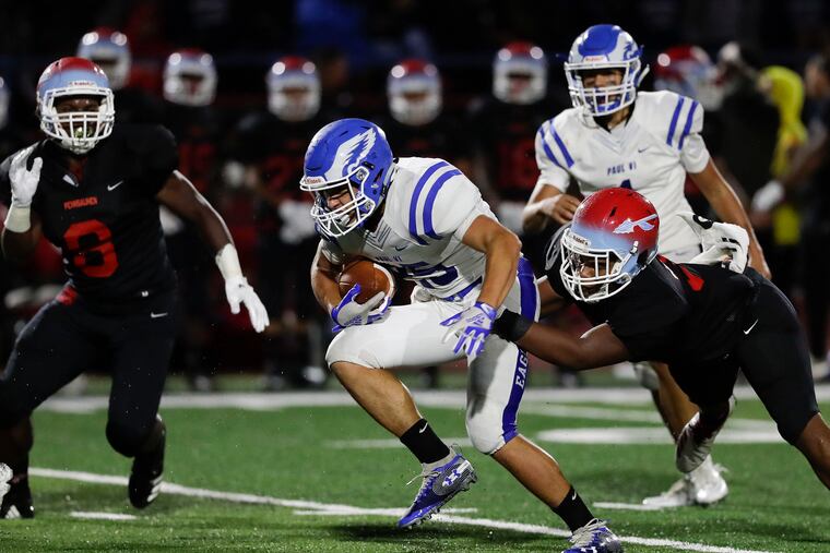 Paul VI High's Vincent Diaco runs against Pennsauken High's Zaire Pitts (right) in the second quarter on Friday, September 6, 2019.