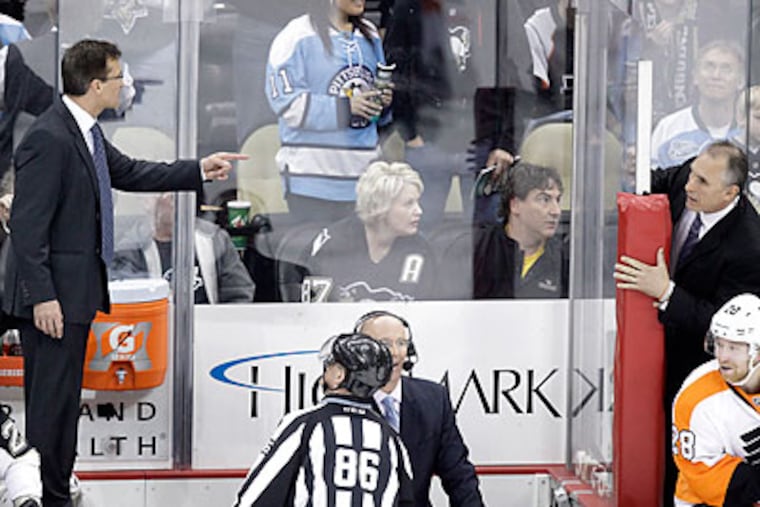 The Flyers' and Penguins' coaches got into a shouting match from their benches late in Sunday's game. (Gene J. Puskar/AP)