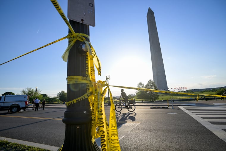 Police tape remains around the scene after a person was shot near the Washington Monument in May 4, 2026, in Washington.