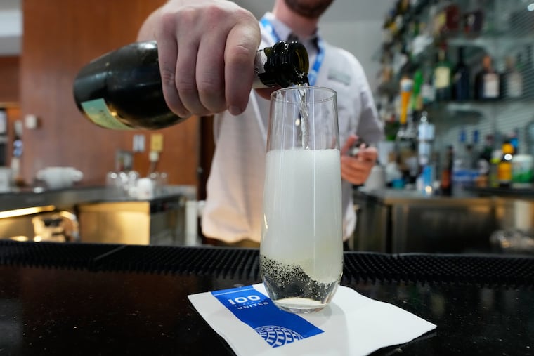 A bartender pours a glass of sparkling wine at the United Club lounge in Minneapolis. The biggest U.S. airlines are expanding their premium cabins and adding more luxury perks to attract high-paying passengers.