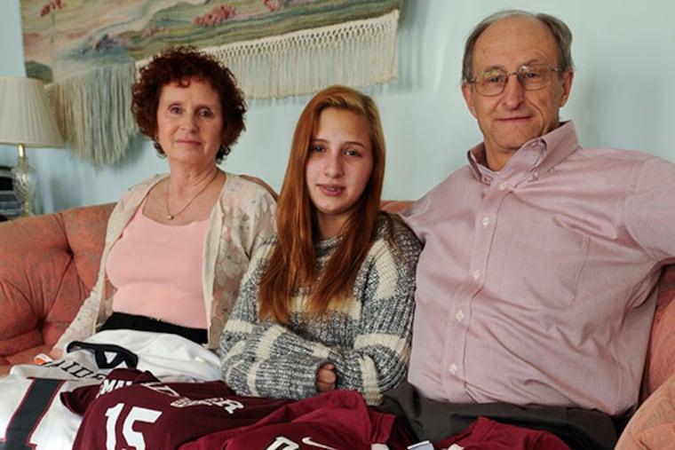 Lee Maxwell and Laurie Burstein-Maxwell and their 14-year-old daughter Samantha in their home with their son Dan's jersey on their laps. ( RON TARVER / Staff Photographer )