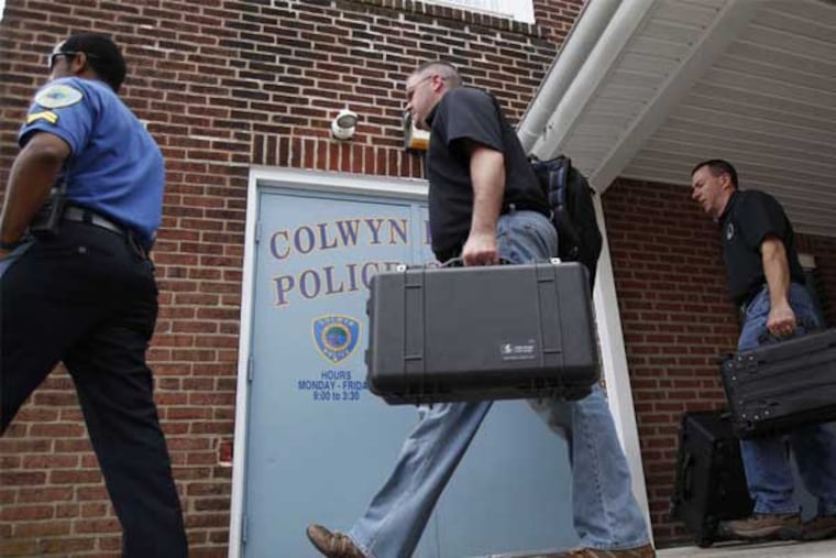 Investigators leave the Colwyn police station. They also searched the borough hall and the safety director's office. (David Maialetti / Staff Photographer)