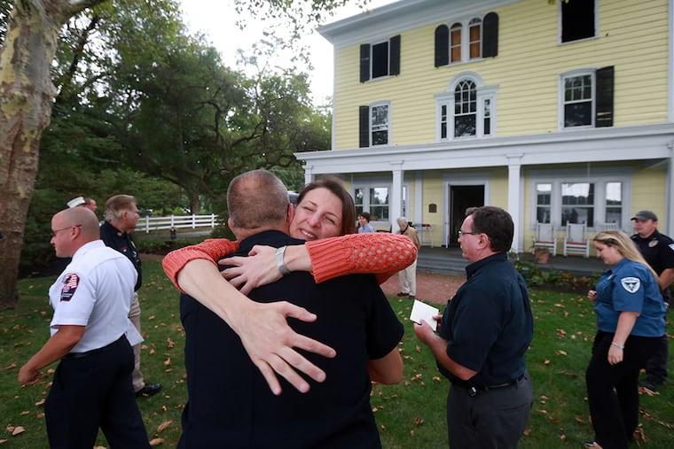 Tama Geergten hugs Willingboro firefighter Jim Anderson. The Geergtens presented $500 checks to each of the first response teams to save precious items from their home after their house nearly burned down on July 2 from a lightning strike. ( DAVID SWANSON / Staff Photographer )