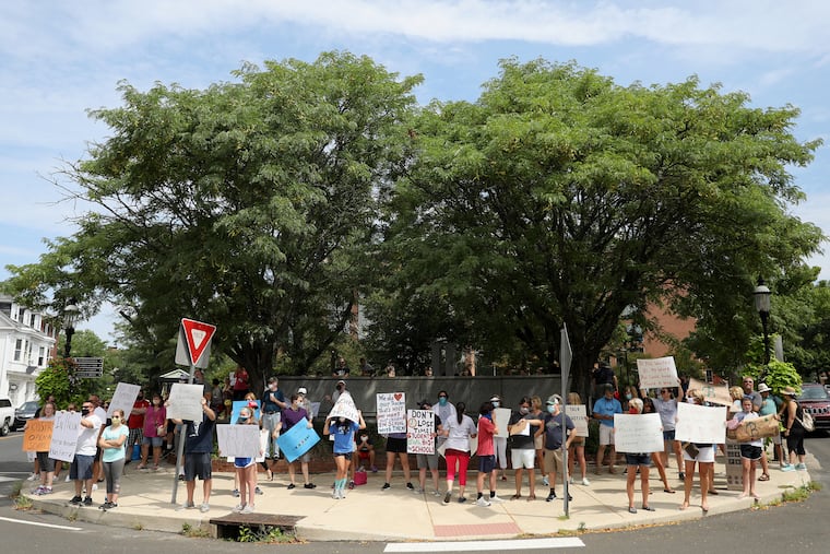 A group comprising mostly parents and students call for the Central Bucks School District to offer in-person classes during a protest in downtown Doylestown, Pa., on Saturday, Aug. 15, 2020. Disputes about COVID-19 safety measures have escalated in the county into threats, lawsuits, and discord.