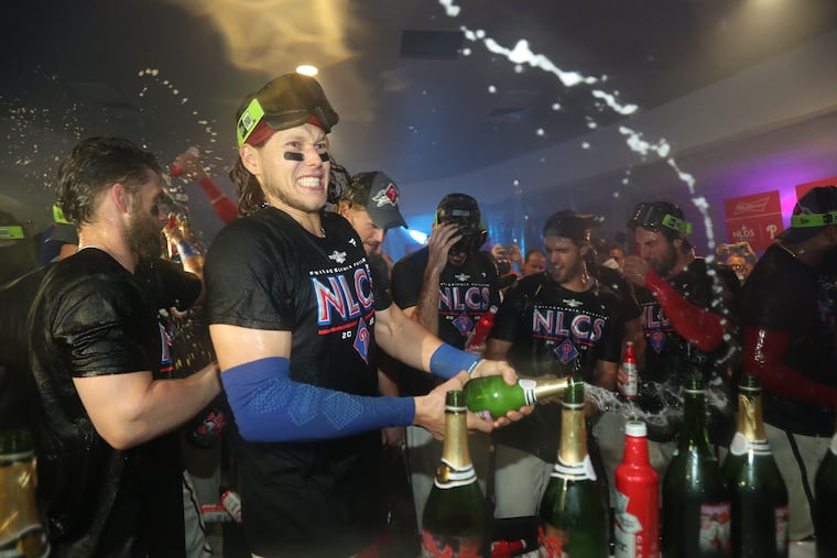 Phillies third baseman Alec Bohm sprays champagne celebrating after the Phillies beat the Braves.