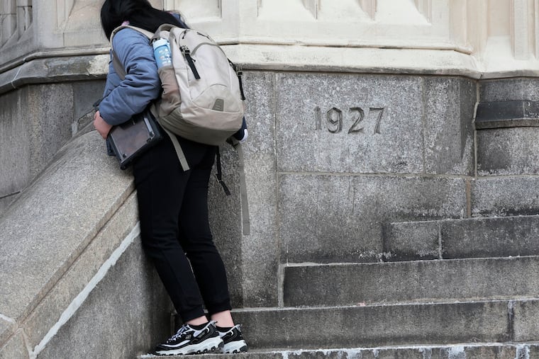 A student stands outside Penn Treaty, a 5-12 school being proposed for closure, in this January file photo.